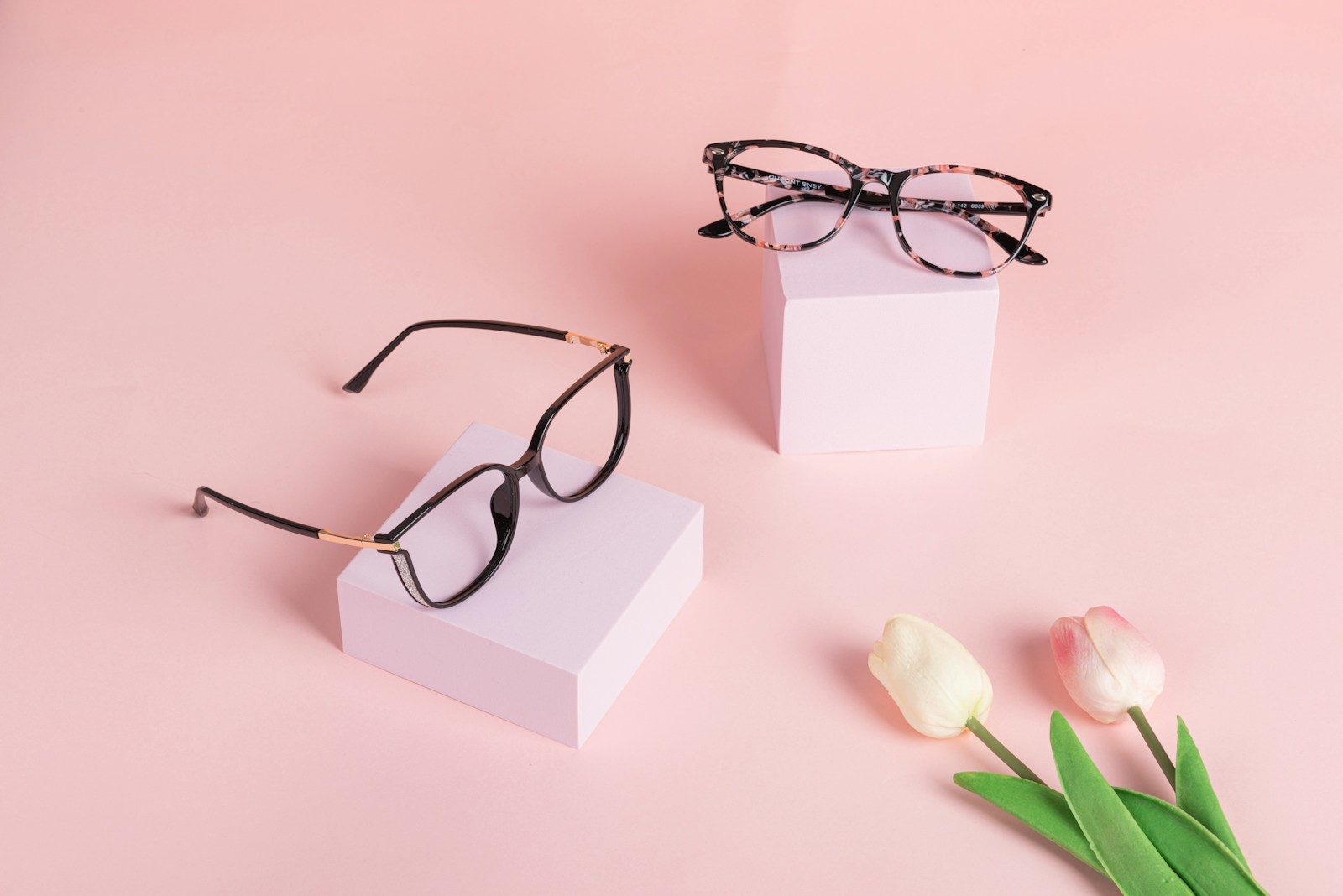 A pair of glasses sitting on top of a white box